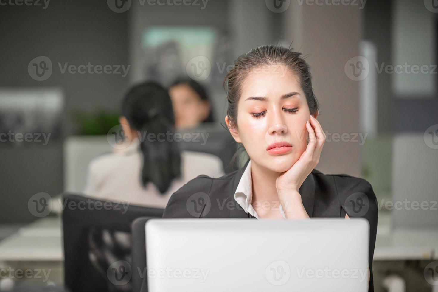 mujer aburrida después del trabajo, empleado desmotivado se siente desinteresado, chica de negocios asiática con un momento de trabajo aburrido foto