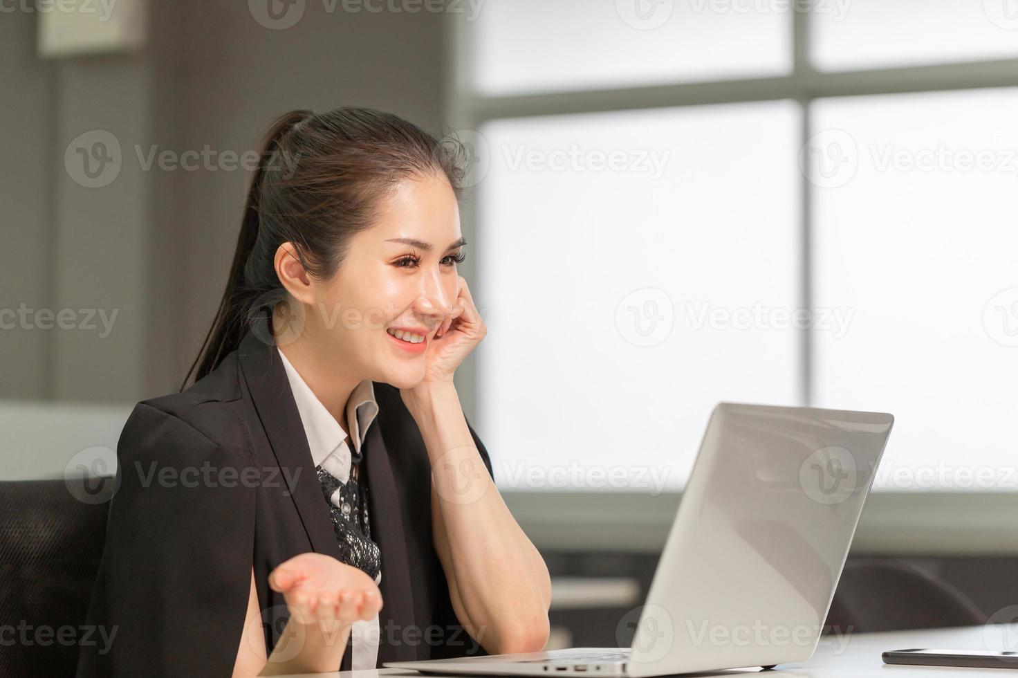 videoconferencia de joven mujer de negocios llamando a una computadora portátil. chica guapa emocionada en la oficina, mujer que trabaja en su oficina en casa foto