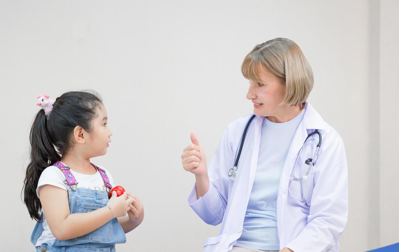 Female doctor support cheer little cute girl examine consult in hospital, Kid on consultation at the pediatrician. Healthcare and medicine concepts photo