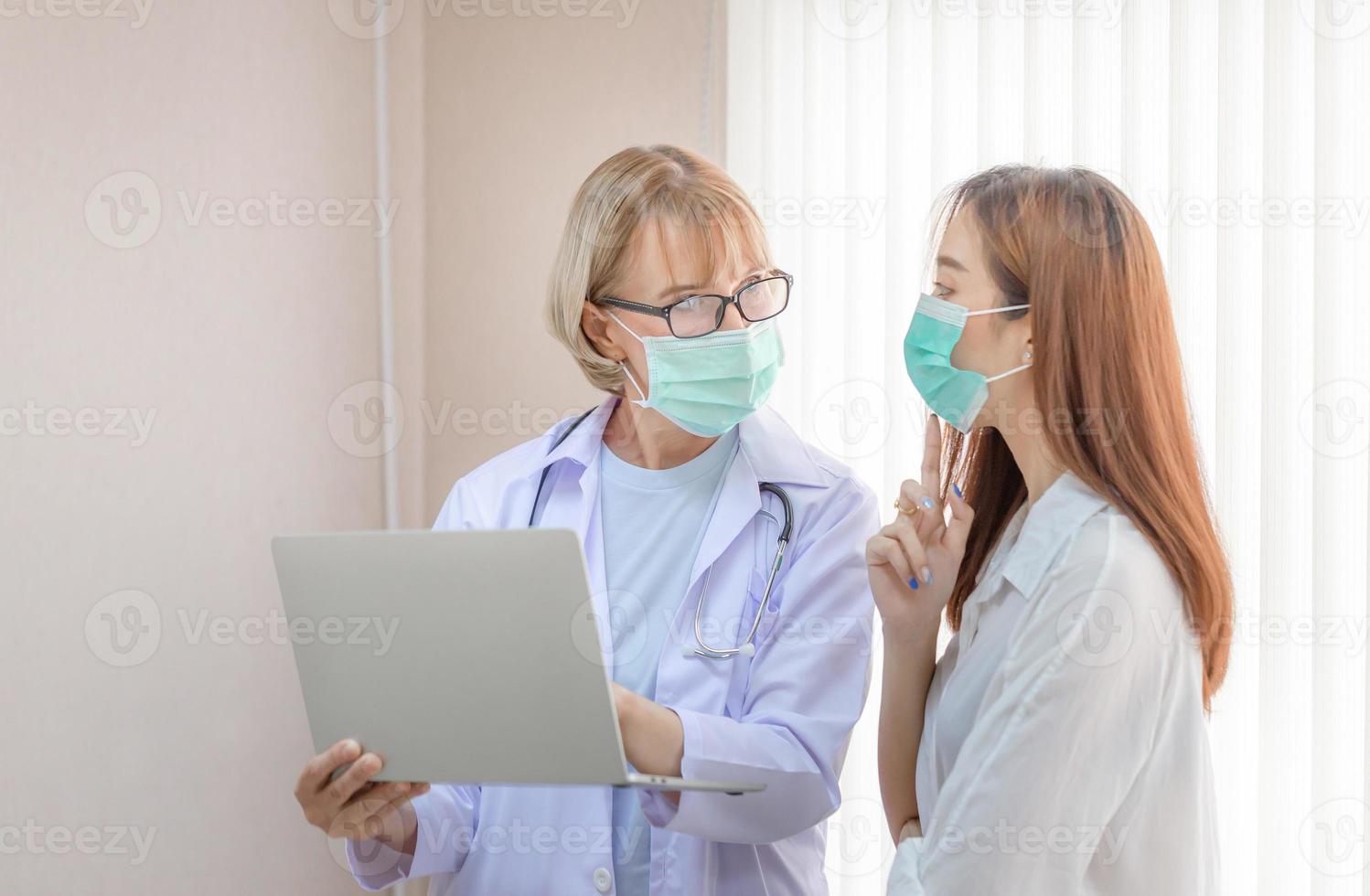 Doctor and patient discussing something while standing at a hospital. Medicine and health care concepts photo