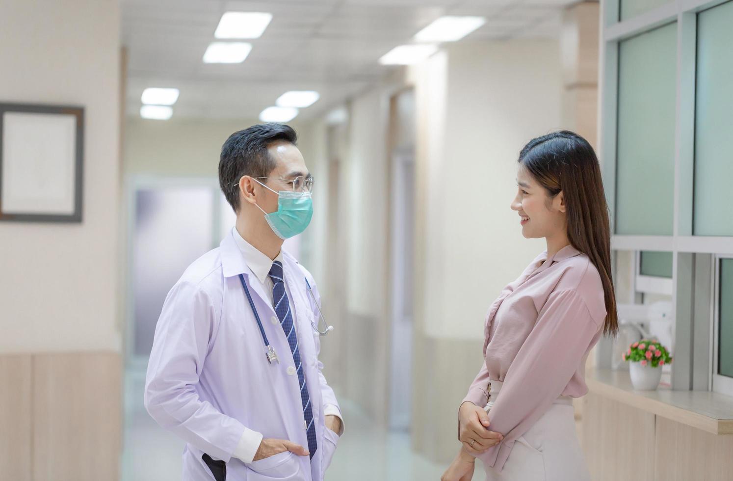 Doctor and patient discussing something while standing at a hospital. Medicine and health care concepts photo