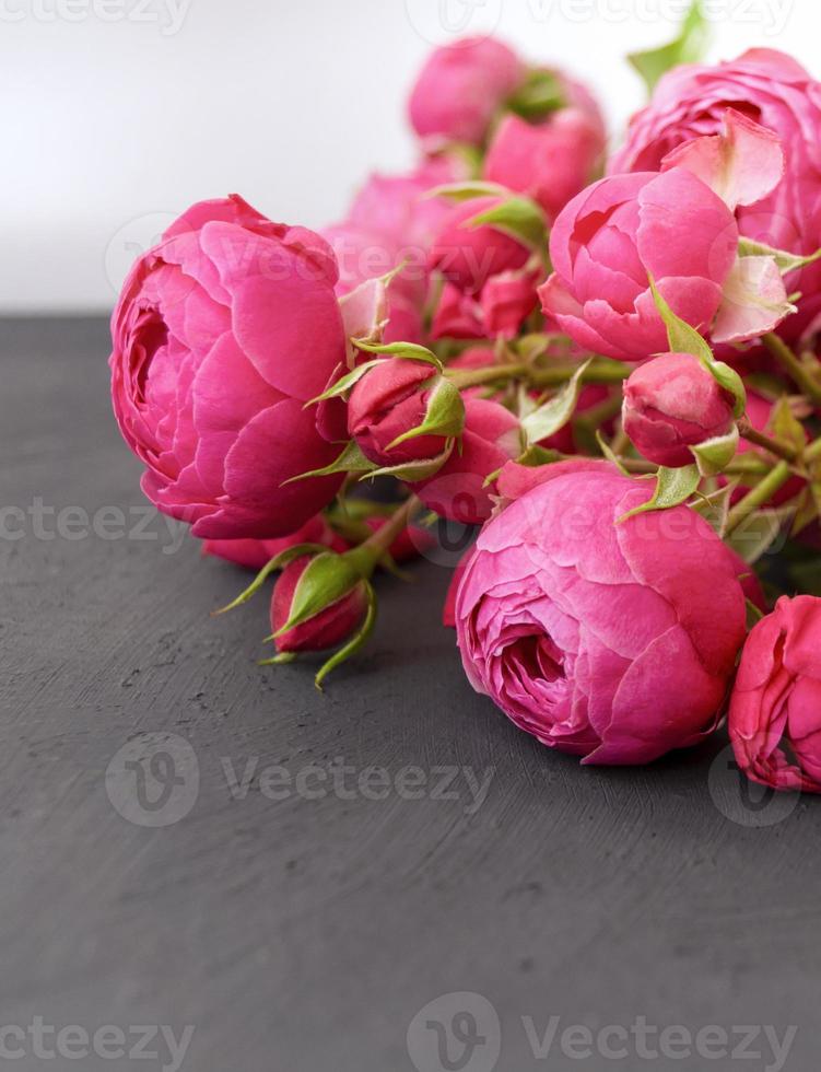A bouquet of roses on a dark gray table, a greeting card template. A form with space for text. photo
