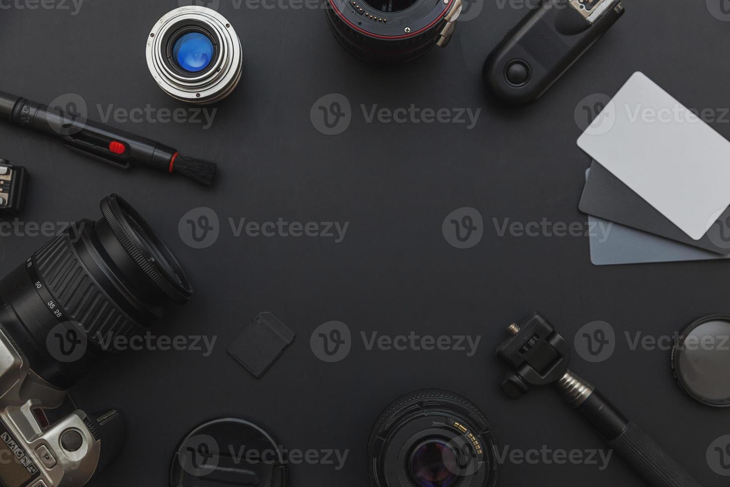 Photographer work place with dslr camera system, camera cleaning kit, lens and camera accessory on dark black table background. Hobby travel photography concept. Flat lay top view copy space. photo