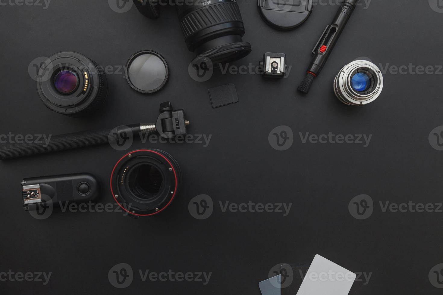 Photographer workplace with dslr camera system, camera cleaning kit, lens and camera accessory on dark black table background. Hobby travel photography concept. Flat lay top view copy space. photo