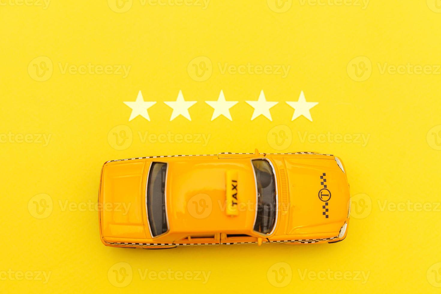 Yellow toy car Taxi Cab and 5 stars rating isolated on yellow background. Smartphone application of taxi service for online searching calling and booking cab concept. Taxi symbol. Copy space. photo