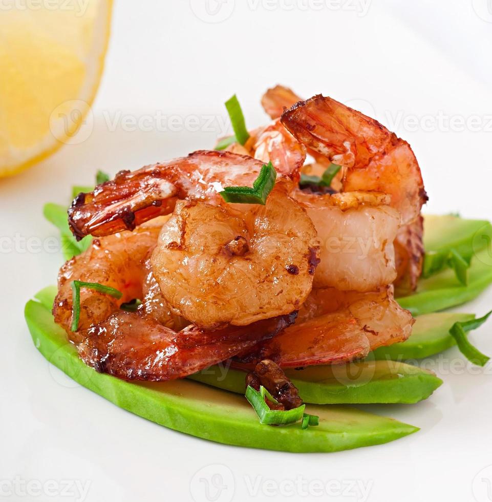 Shrimp sauteed with garlic and soy sauce on a cushion of avocado slices photo