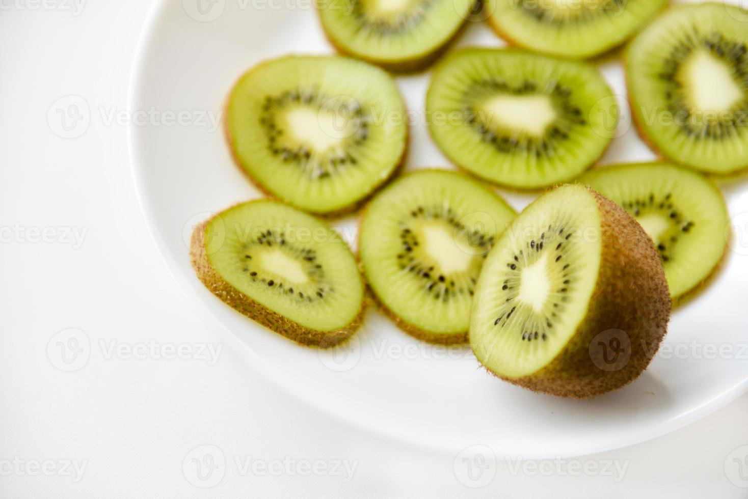 Kiwi fruit sliced on a white plate photo