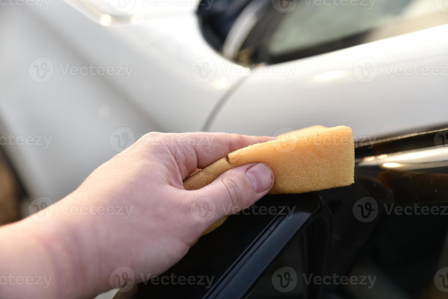 Washing a white car with a sponge by hand photo