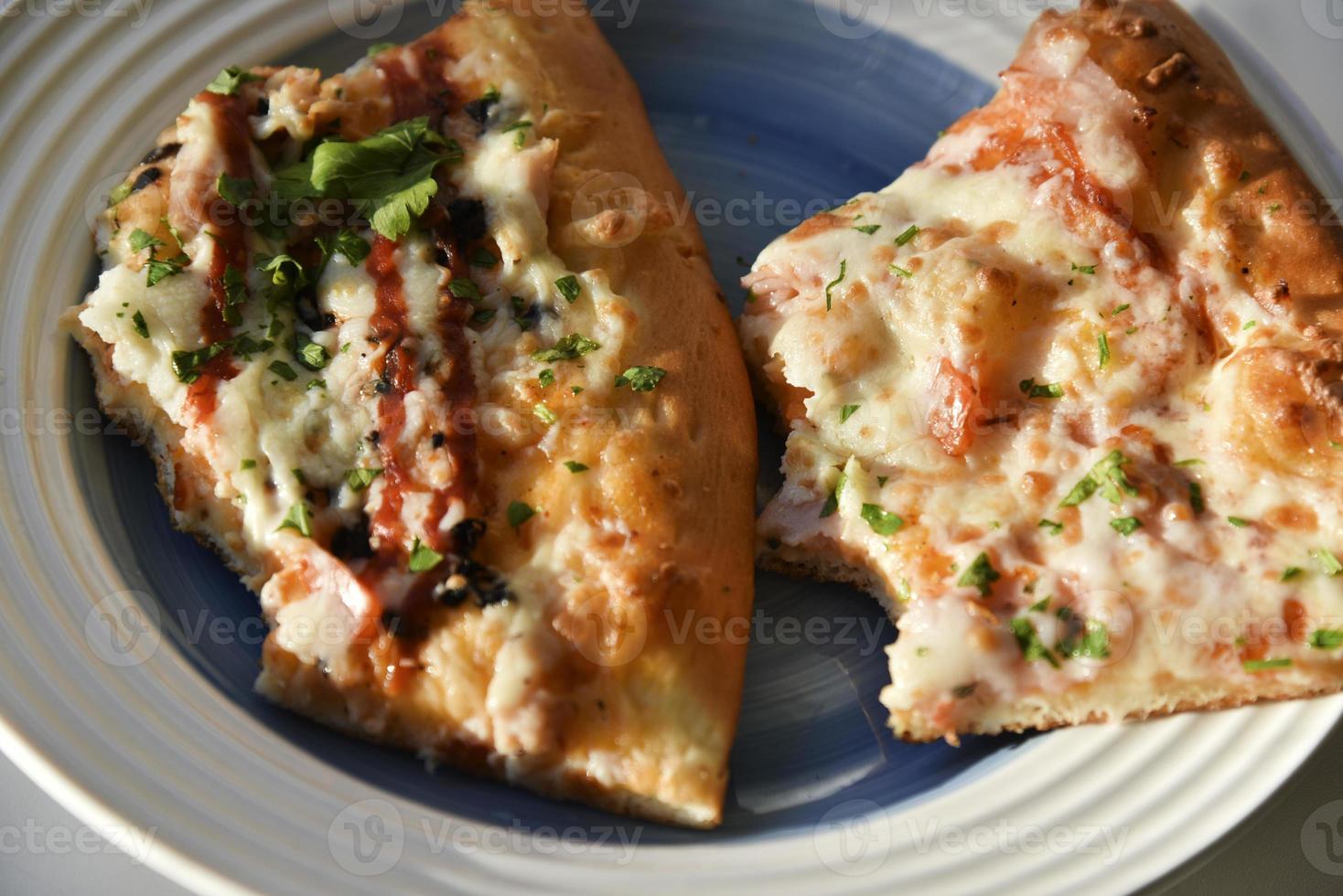 Triangular slice of pizza on a white plate photo