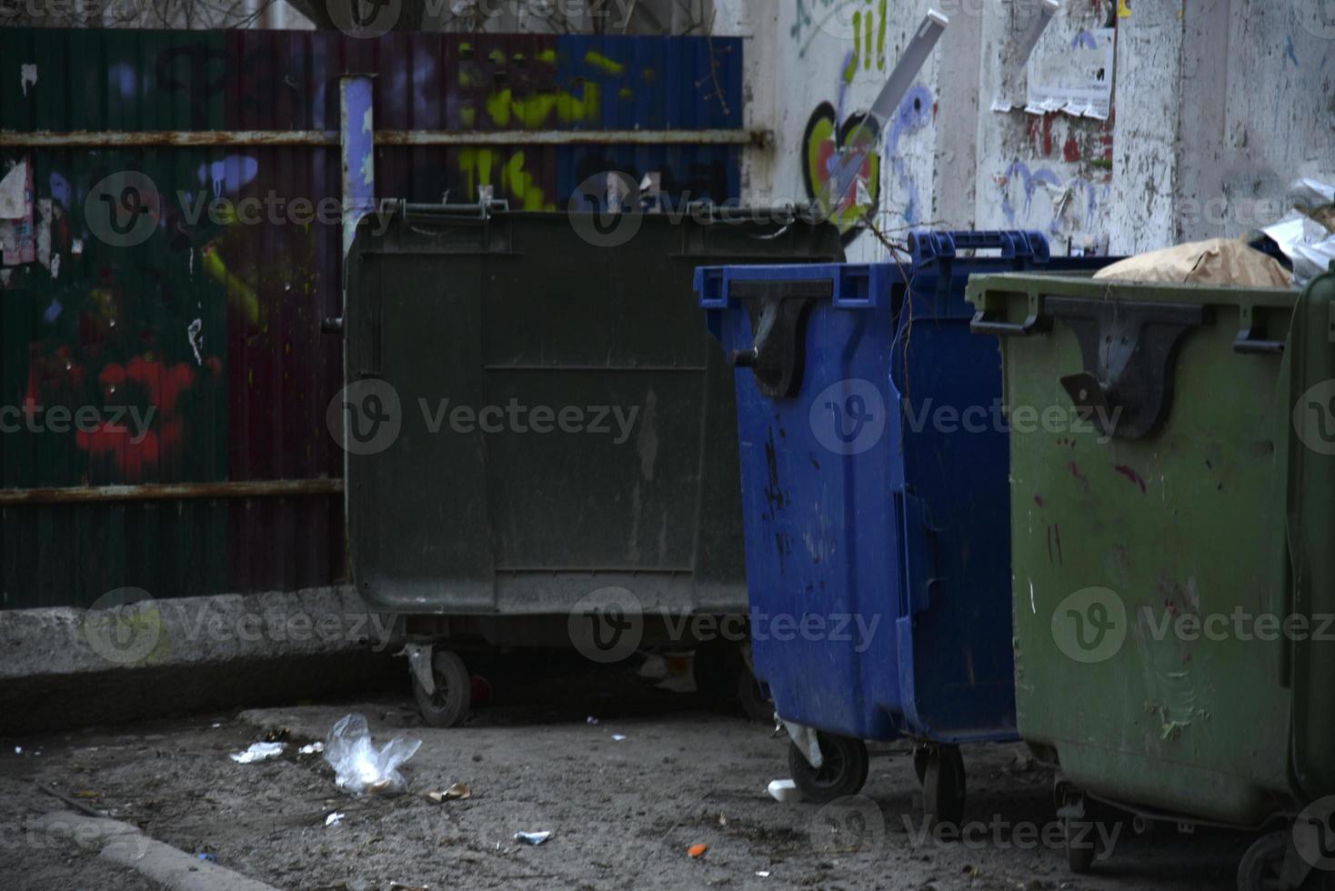 contenedores de basura y bolsas con basura en la calle foto