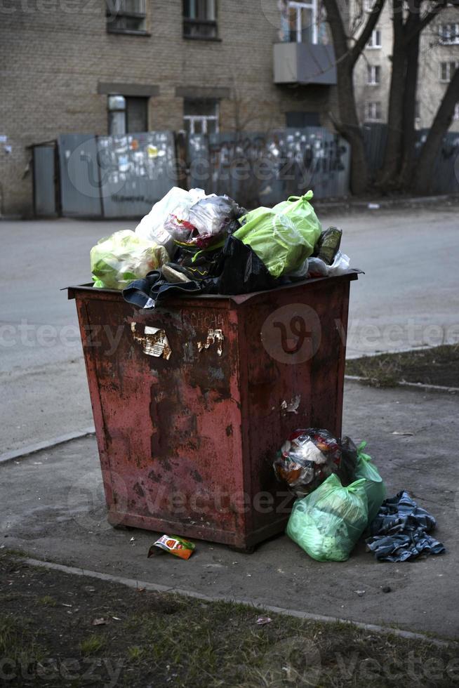 contenedores de basura y bolsas con basura en la calle foto