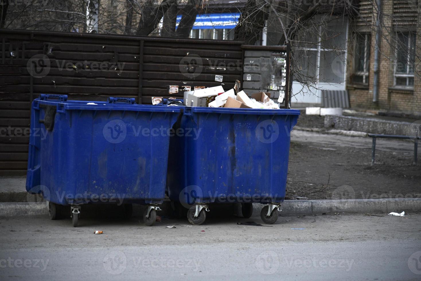 contenedores de basura y bolsas con basura en la calle foto