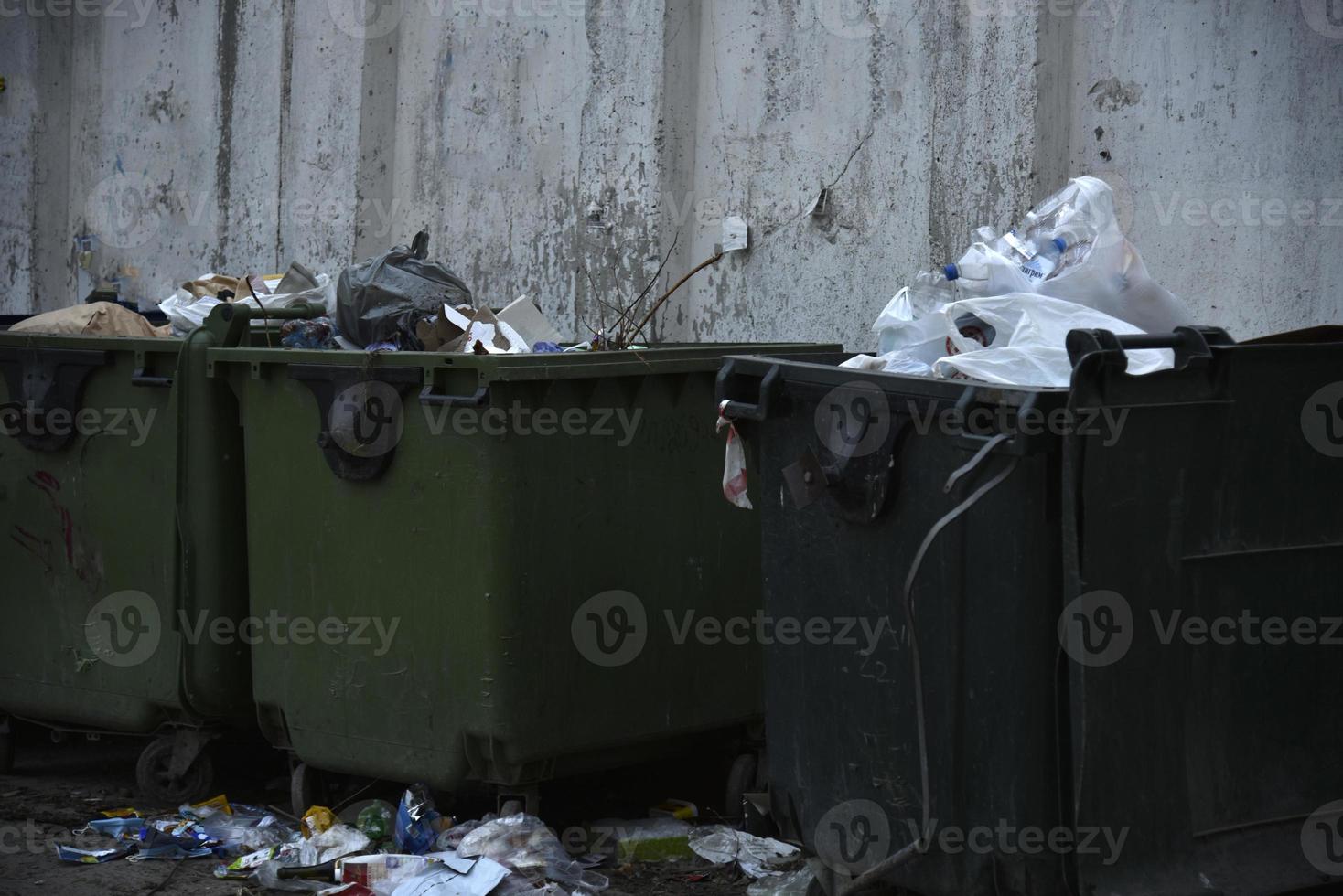 contenedores de basura y bolsas con basura en la calle foto