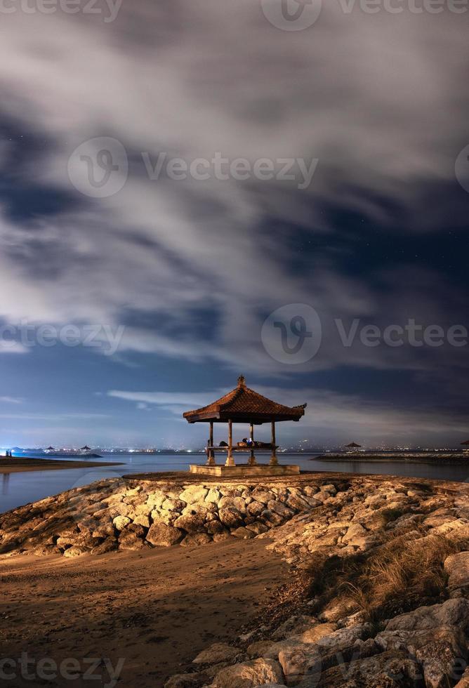 Pavilion on rock jetty with cloudy in sanur beach photo