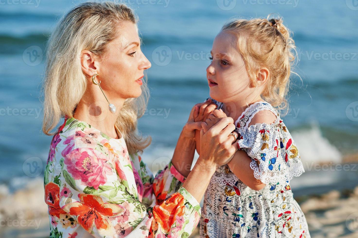 madre e hija hermosa divirtiéndose en la playa. retrato de mujer feliz con linda niña de vacaciones. foto