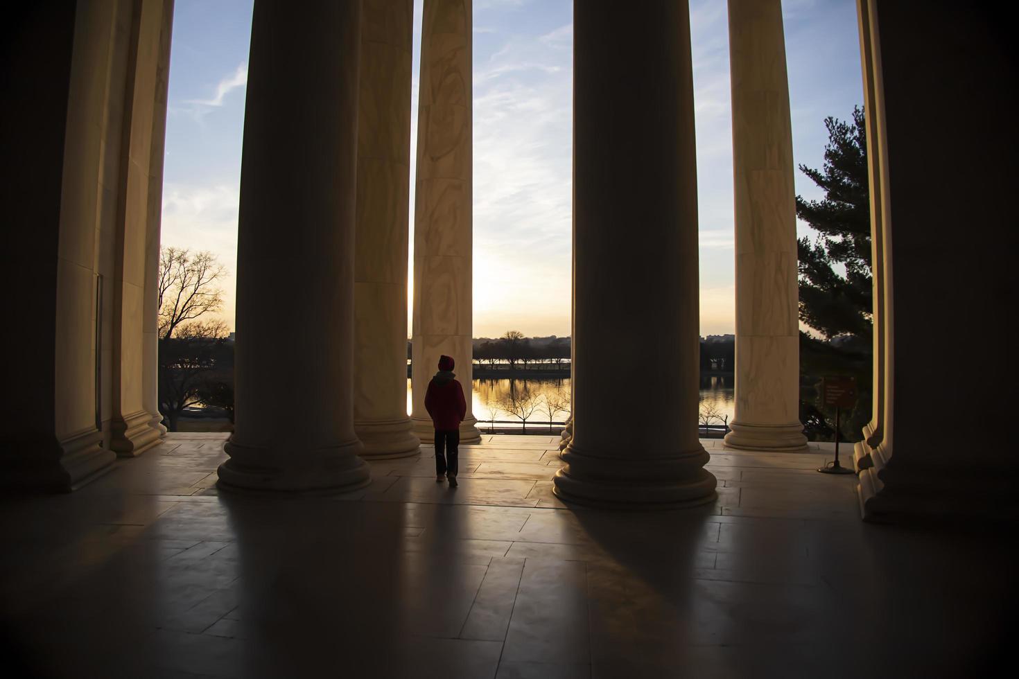 Children playing near giant pillars at a monument when the sun is setting photo