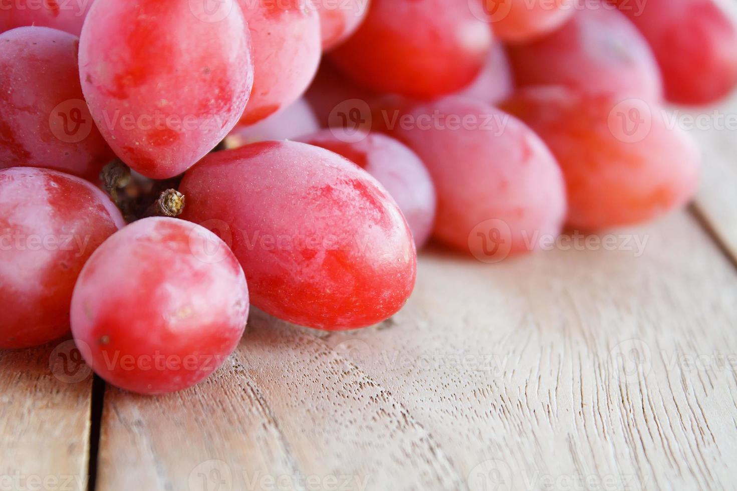 uvas rojas sobre fondo de madera foto