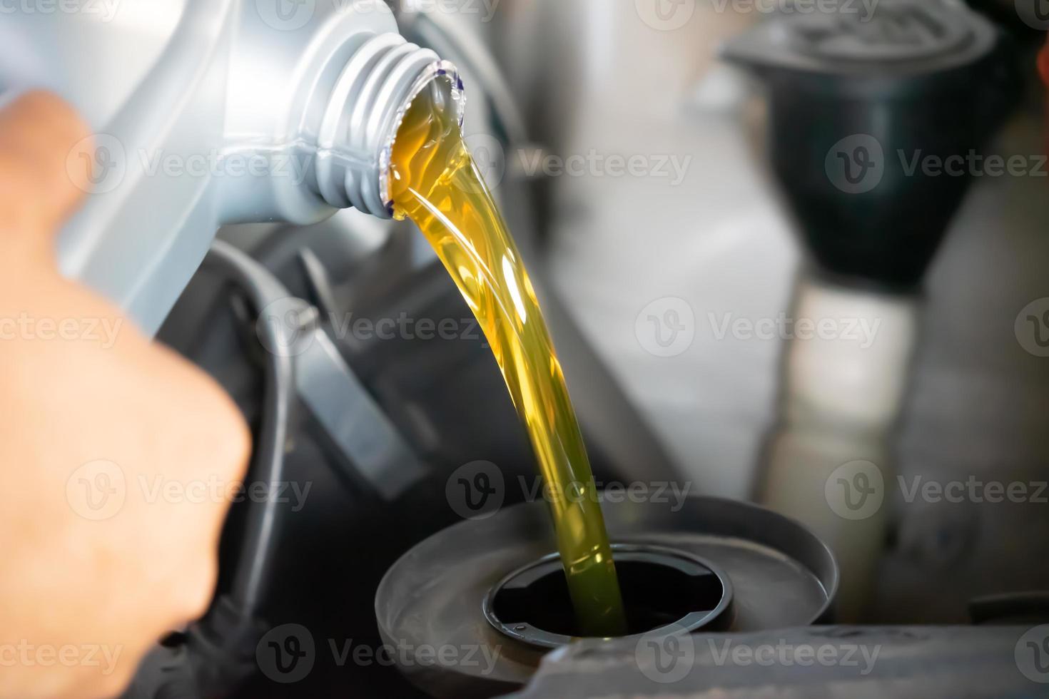 Pouring engine oil to car engine. Fresh oil poured during an oil change to a car. photo