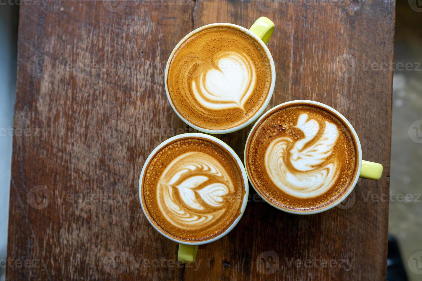 Top view of Latte coffee or cappuccino coffee in white cup with beautiful tree latte art on wooden table. photo