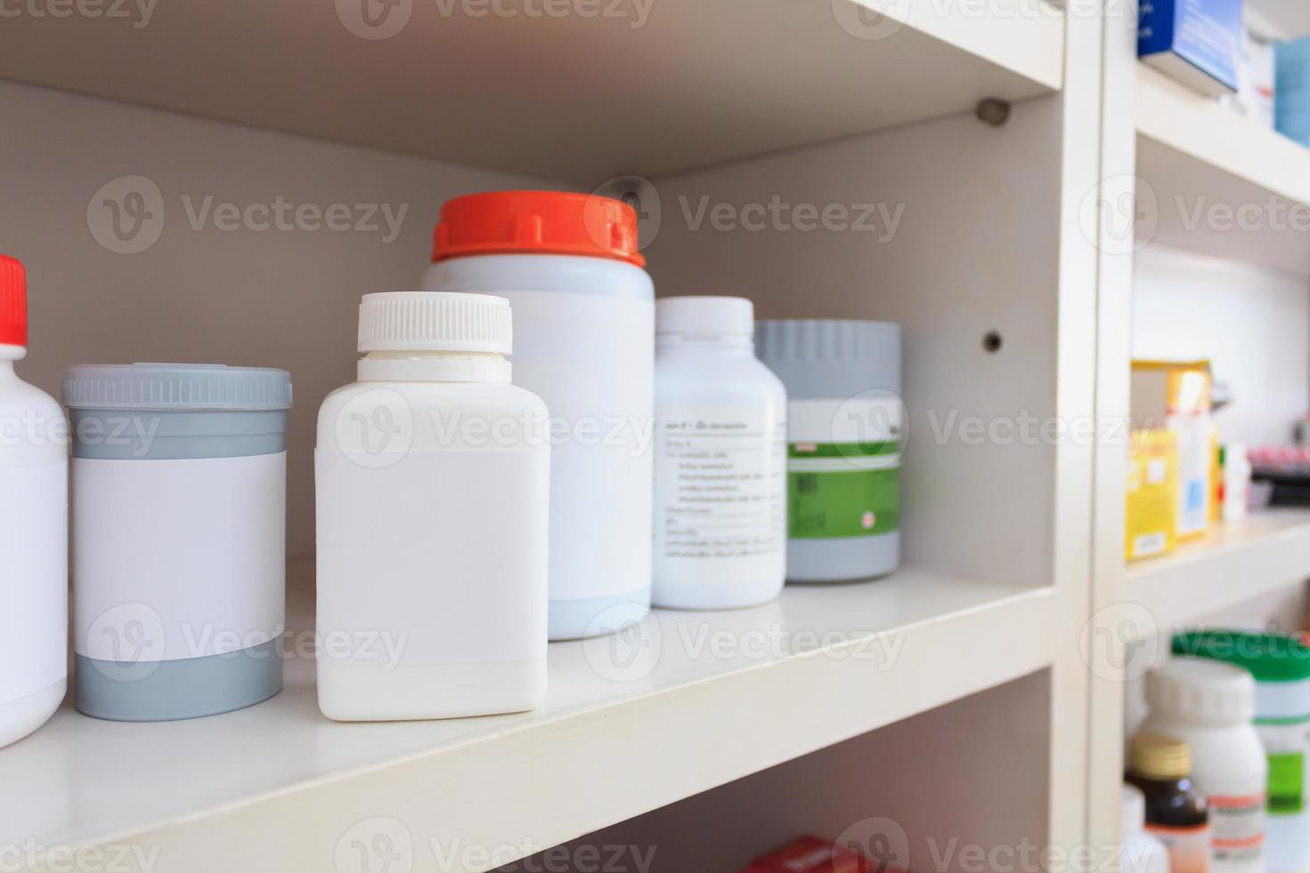 medicine bottles arranged on shelf at drugstore photo