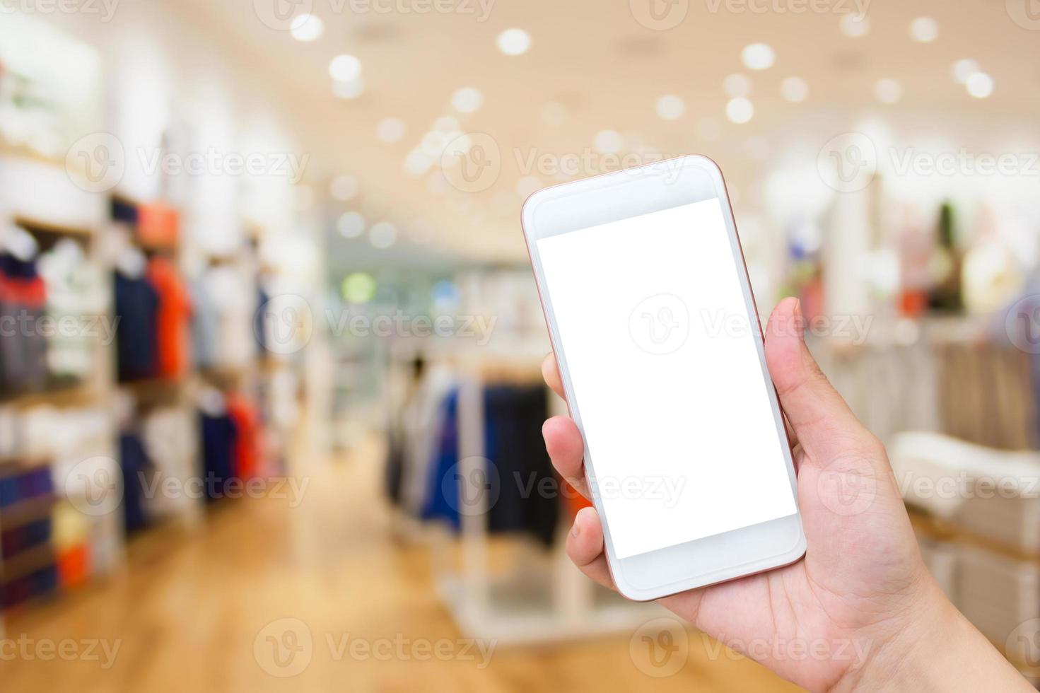 mujer usando celular en tienda de ropa foto