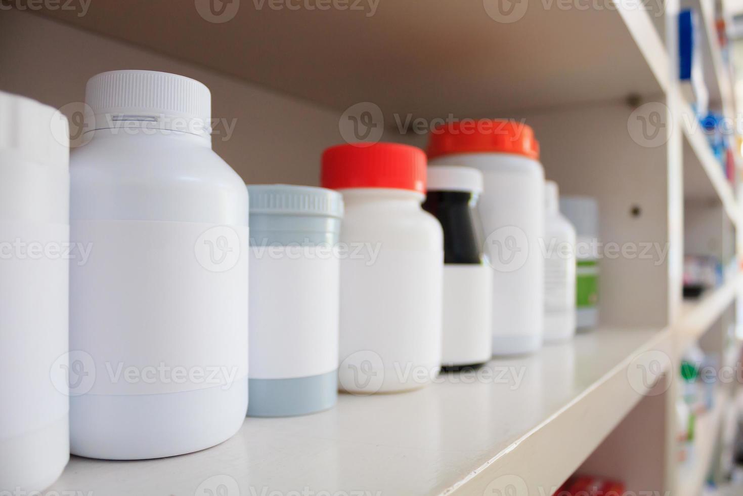 medicine bottles arranged on shelf at drugstore photo