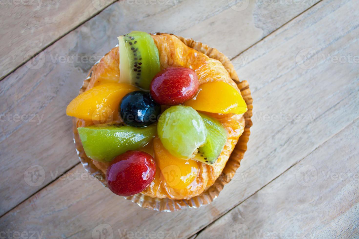 close up danish pastry with fruit on wood table photo