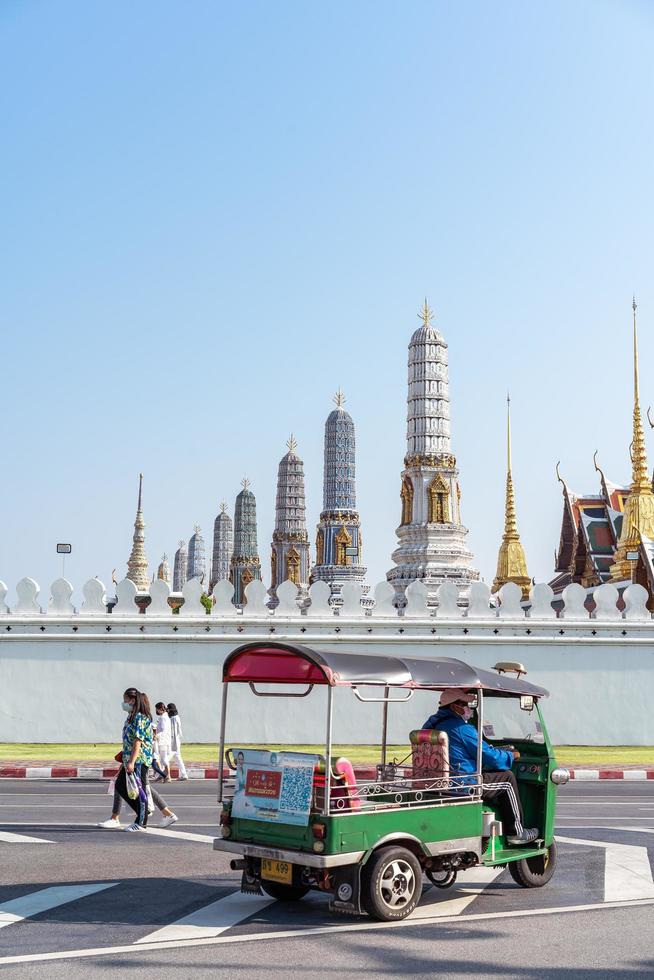 bangkok tailandia 13 de abril de 2022 tuk tuk frente a wat phra kaew, el templo del buda esmeralda y el gran palacio. lujoso palacio real de bangkok. foto