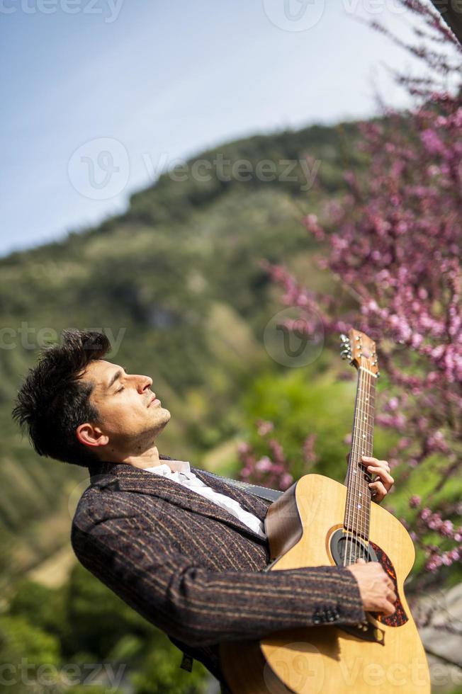 niño toca la guitarra en la naturaleza foto