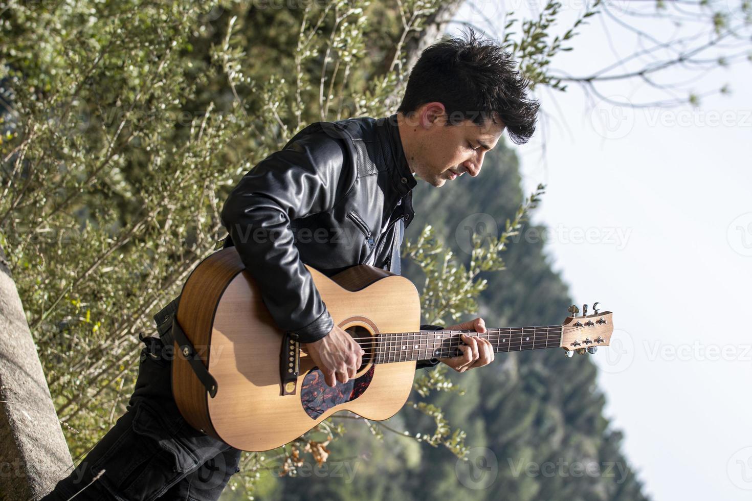 boy plays guitar in nature photo