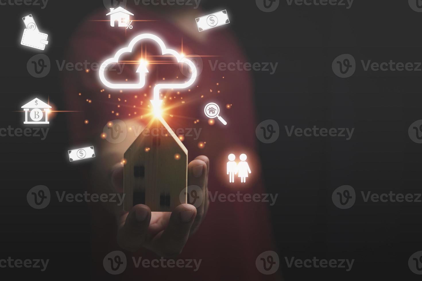 A bank loan for buying houses concept. Real estate investment, Finance, Accounting, Banking. A man holding a small wooden house model on hand with cloud computing and Icon business, and technology. photo