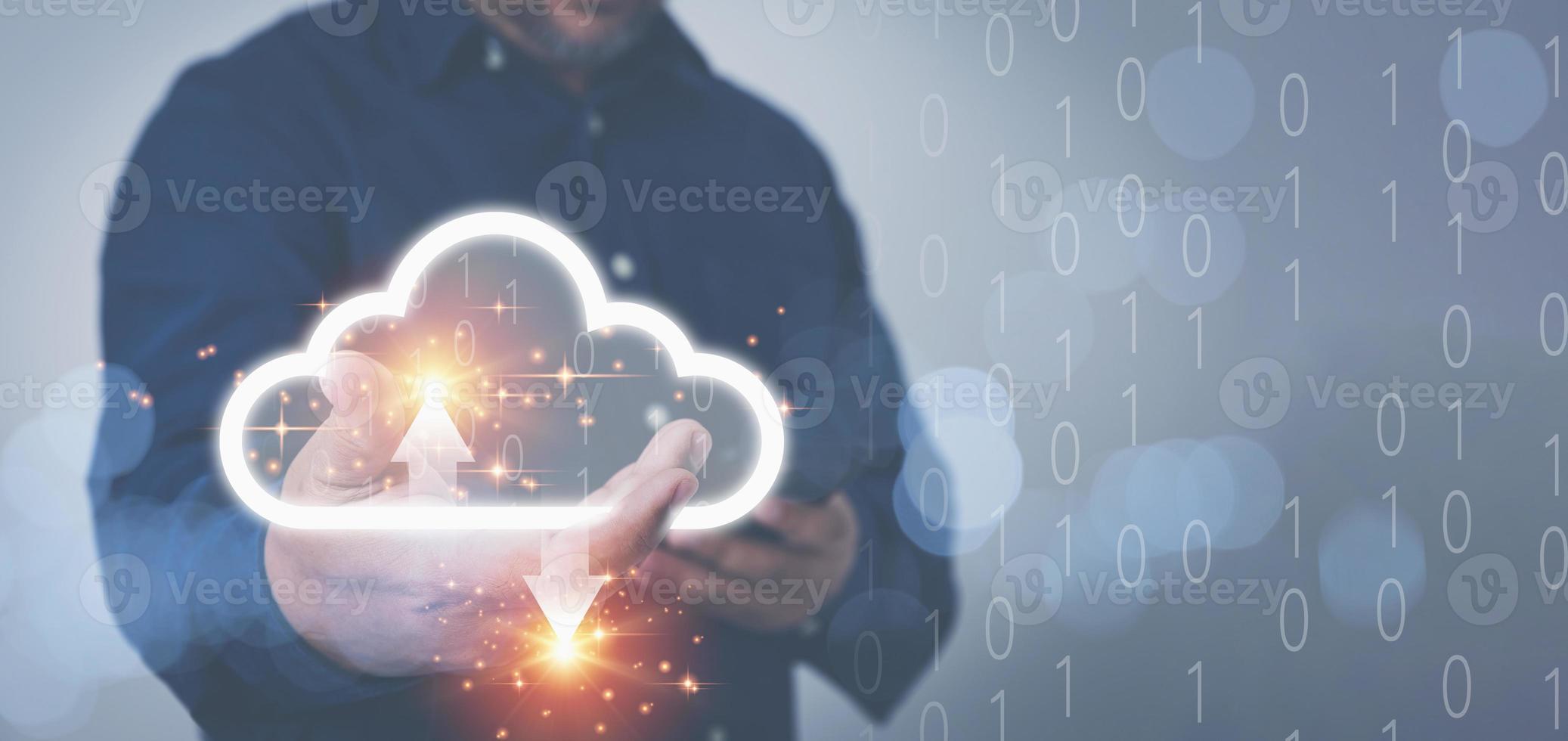 Businessman holding virtual clouds computing and using a smartphone to transfer data information upload or download database corporate with copy space. Technology transformation databases concept. photo