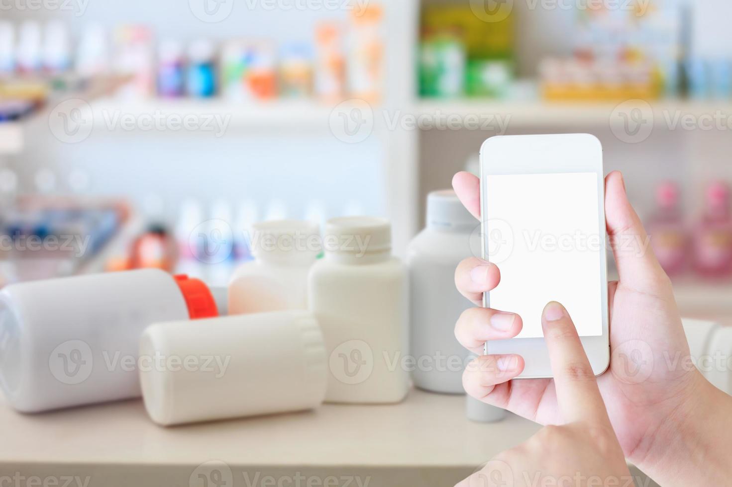 female hold mobile smartphone in the pharmacy photo