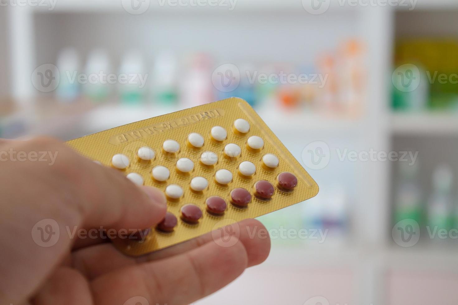 Close up of pharmacist hands holding contraceptive pills photo
