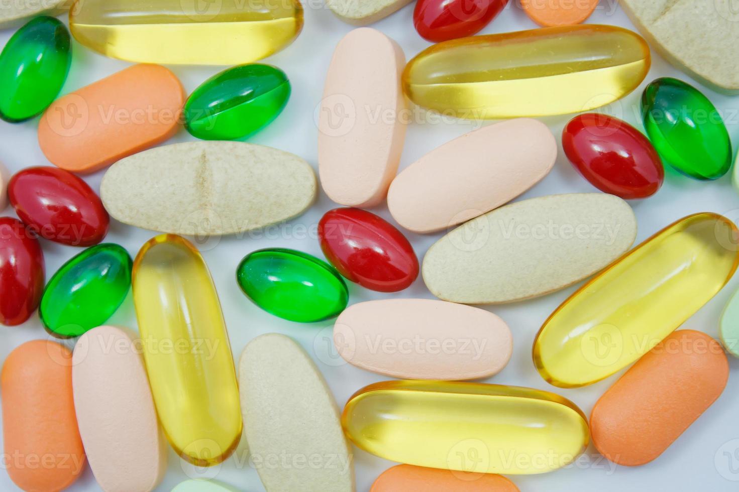 Many colorful pills on white background photo