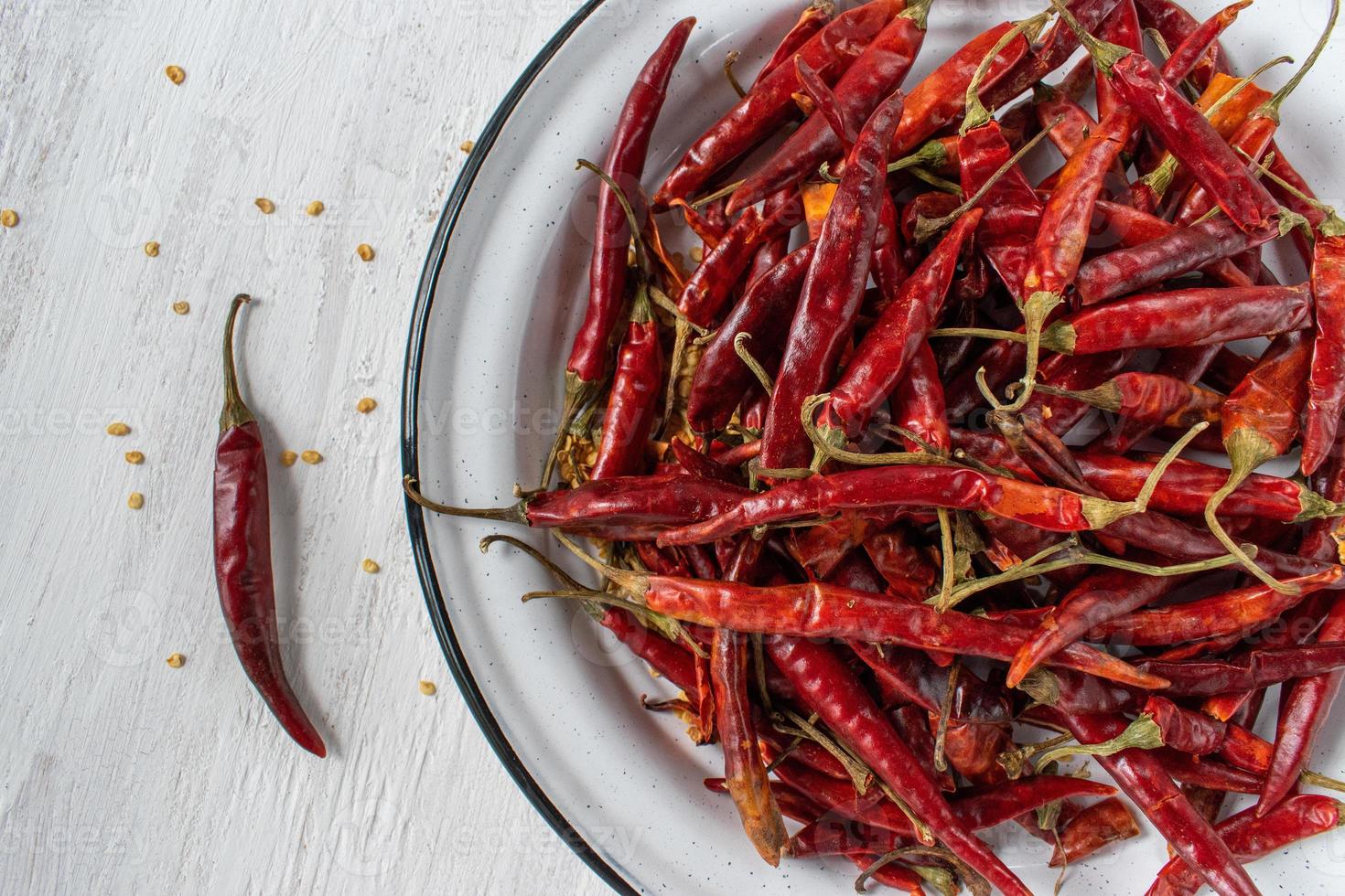 Red Chile de arbol chilis on rustic white background flat lay photo