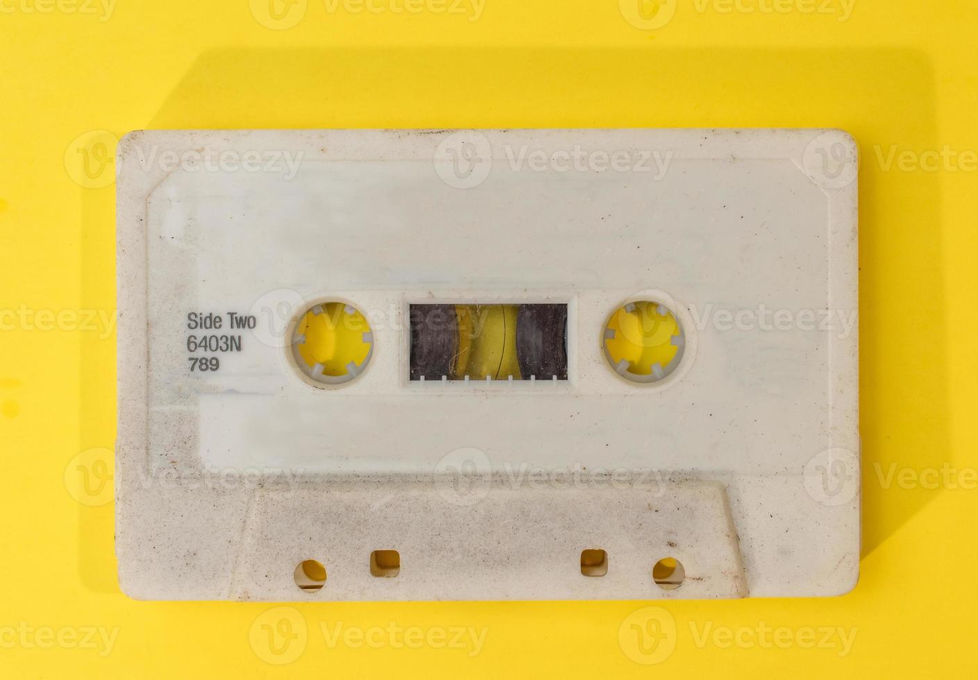 old retro cassette tape with grunge label on yellow background flat lay photo