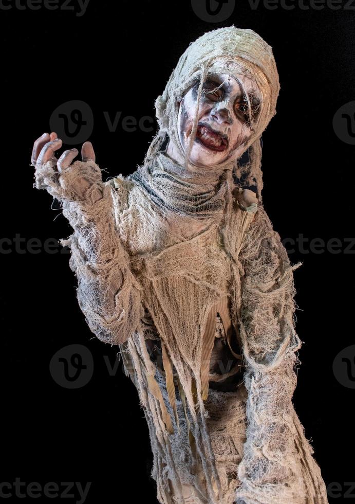 studio shot portrait of young boy in costume dressed as a Halloween, cosplay of scary mummy pose on isolated black background photo