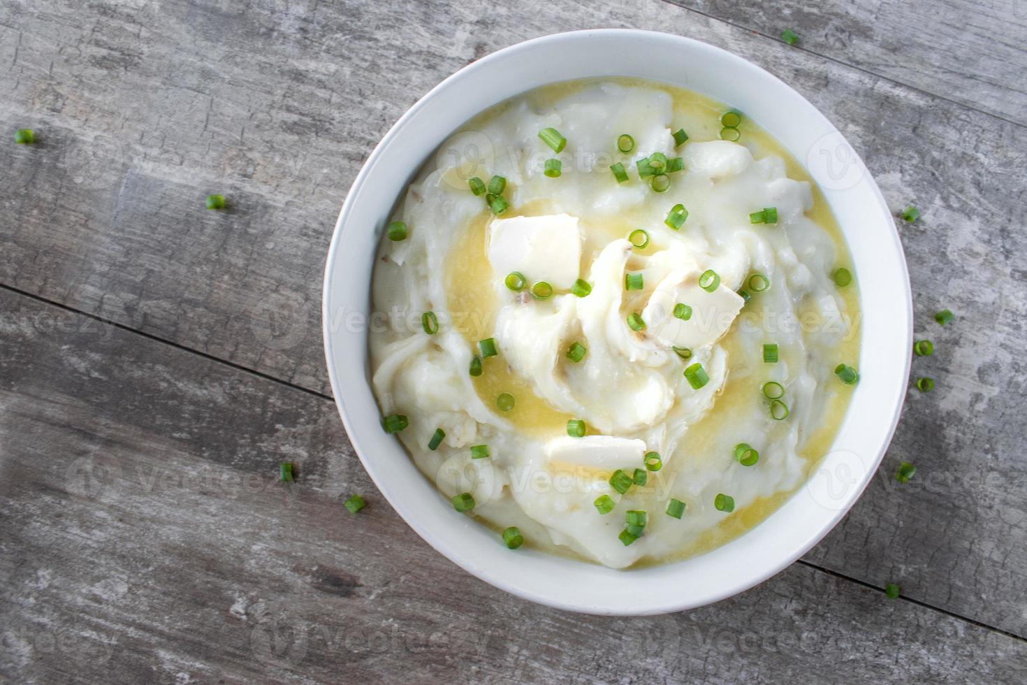 homemade bowl of mashed potatoes and green onions with butter flat lay