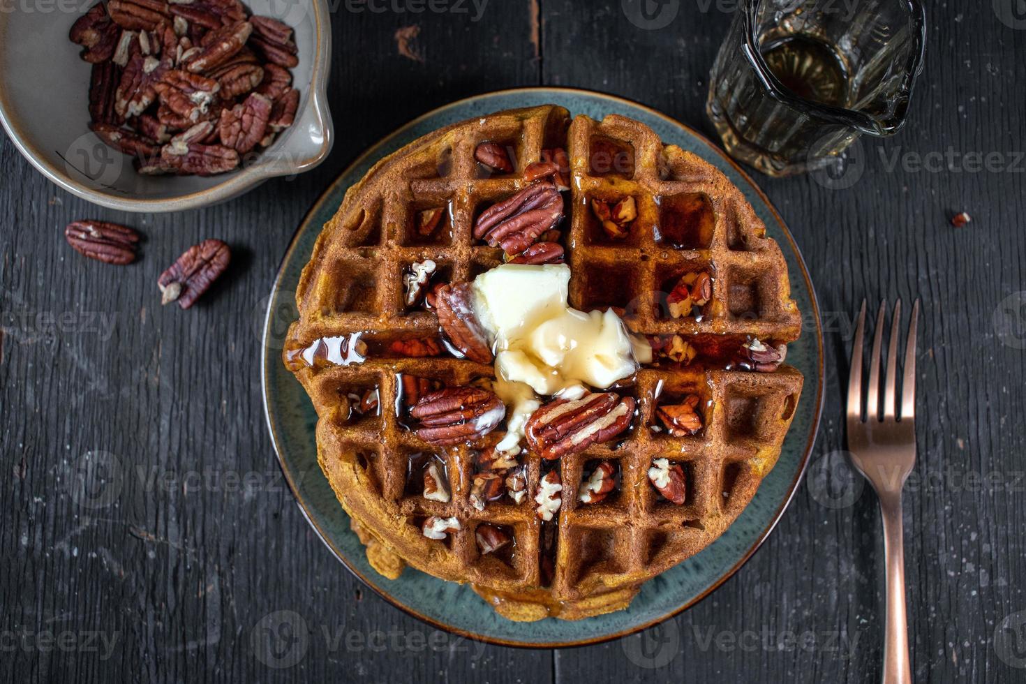 pumpkin waffles with pecans topped with butter and syrup flat lay photo
