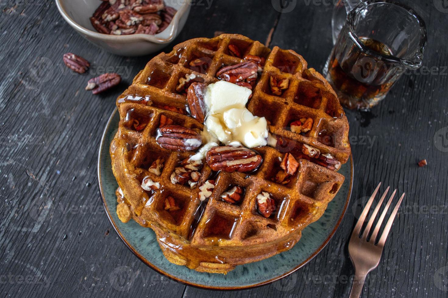 pumpkin waffles with pecans topped with butter and syrup flat lay photo