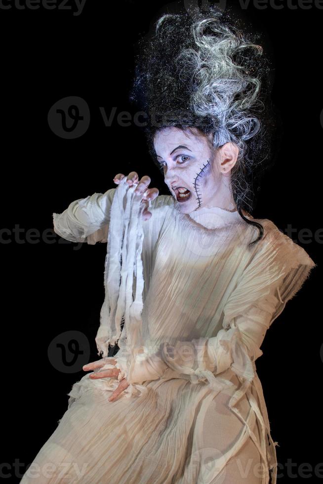 foto de estudio retrato de una joven disfrazada de halloween, cosplay de la aterradora novia de frankenstein posan sobre un fondo negro aislado