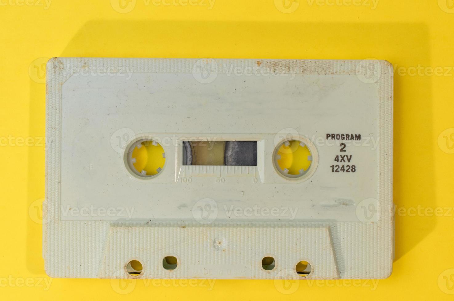 old retro cassette tape with grunge label on yellow background flat lay photo