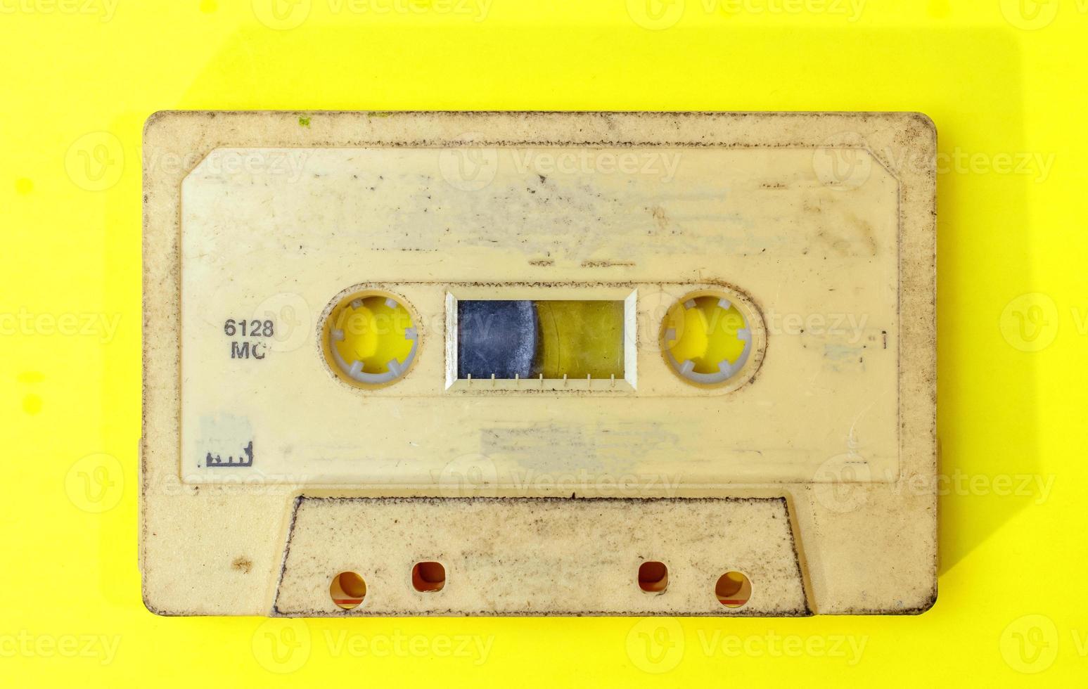 old retro cassette tape with grunge label on yellow background flat lay photo