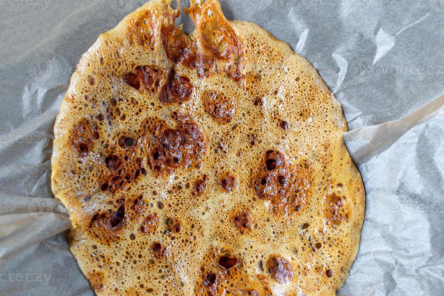 golden homemade honeycomb candy poured onto wax paper flat lay photo