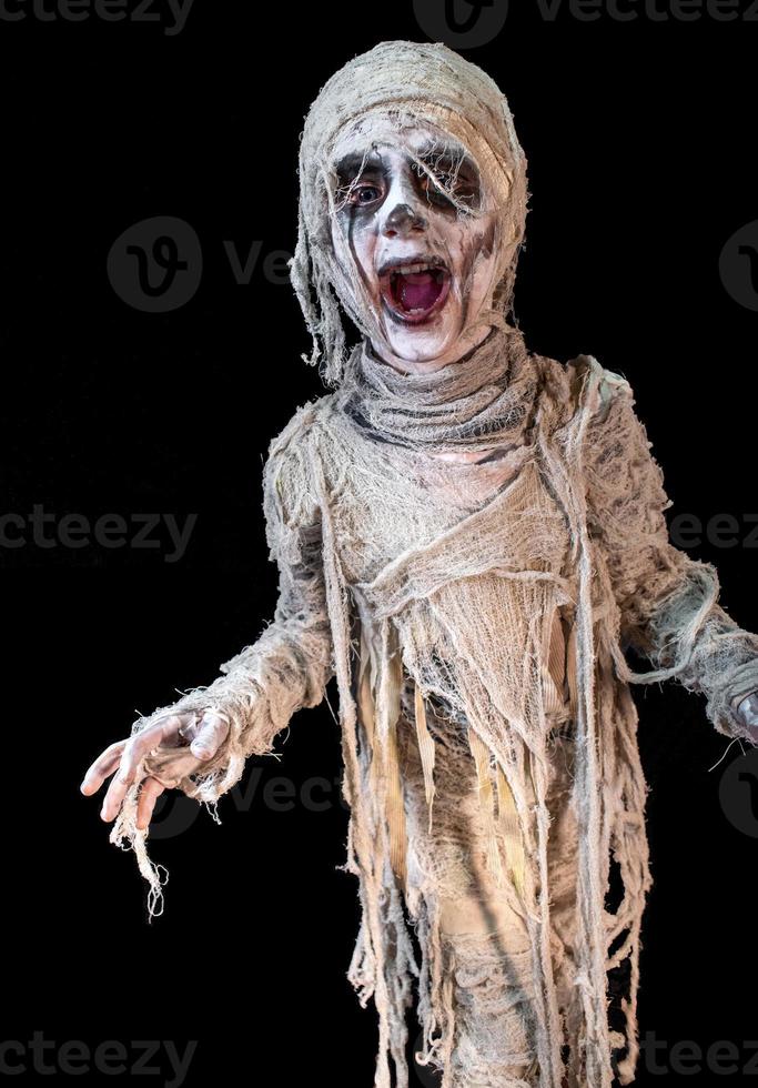 studio shot portrait of young boy in costume dressed as a Halloween, cosplay of scary mummy pose on isolated black background photo