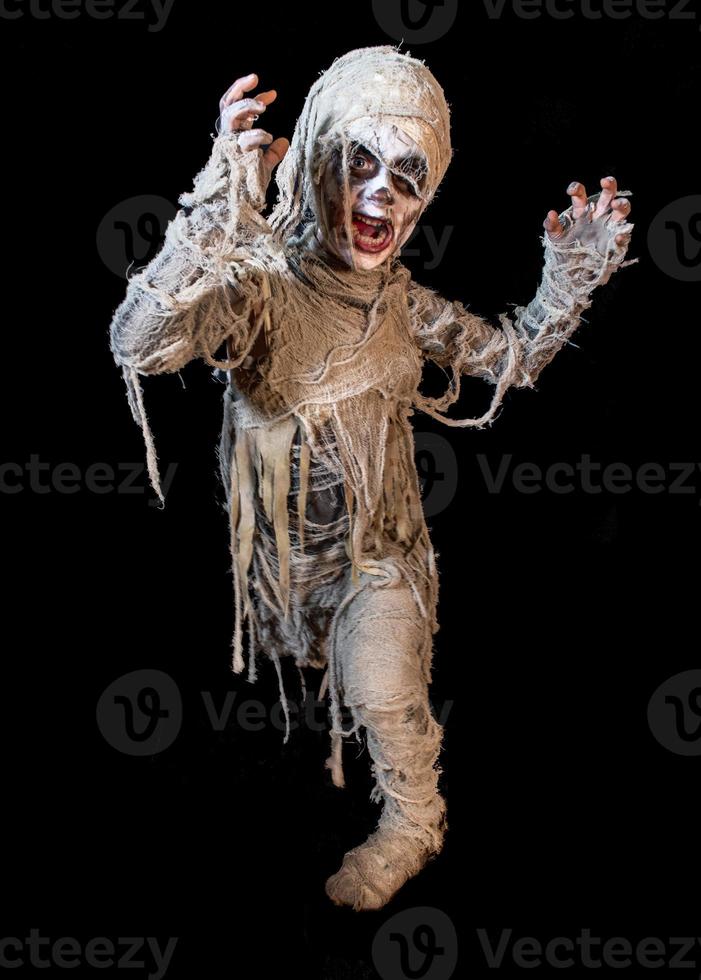 studio shot portrait of young boy in costume dressed as a Halloween, cosplay of scary mummy pose on isolated black background photo