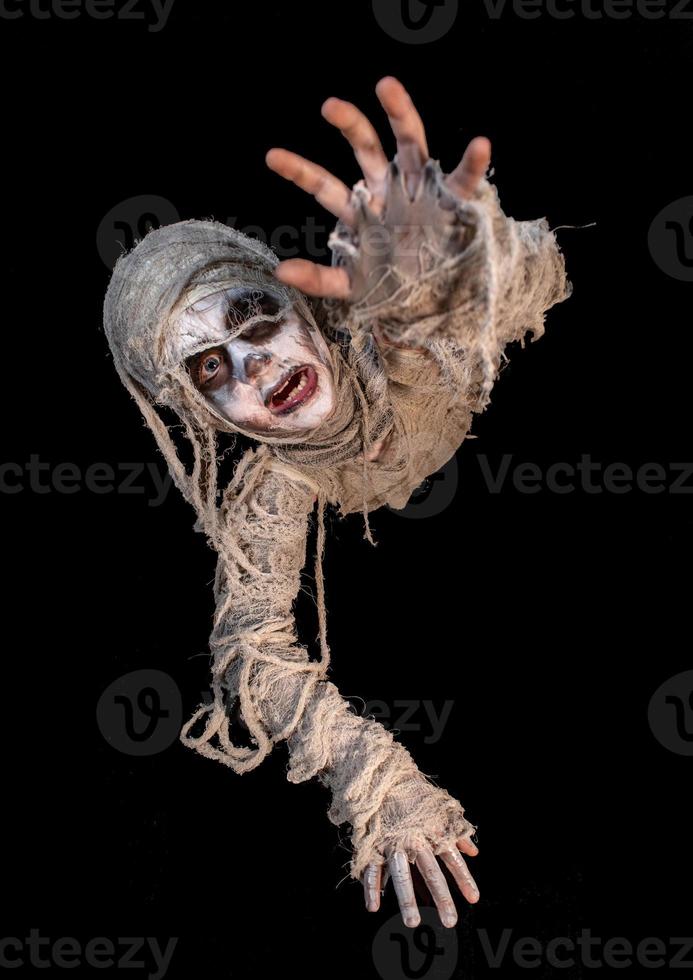 studio shot portrait of young boy in costume dressed as a Halloween, cosplay of scary mummy pose on isolated black background photo