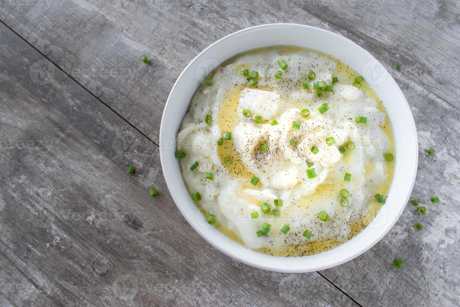 homemade bowl of mashed potatoes and green onions with butter flat lay photo