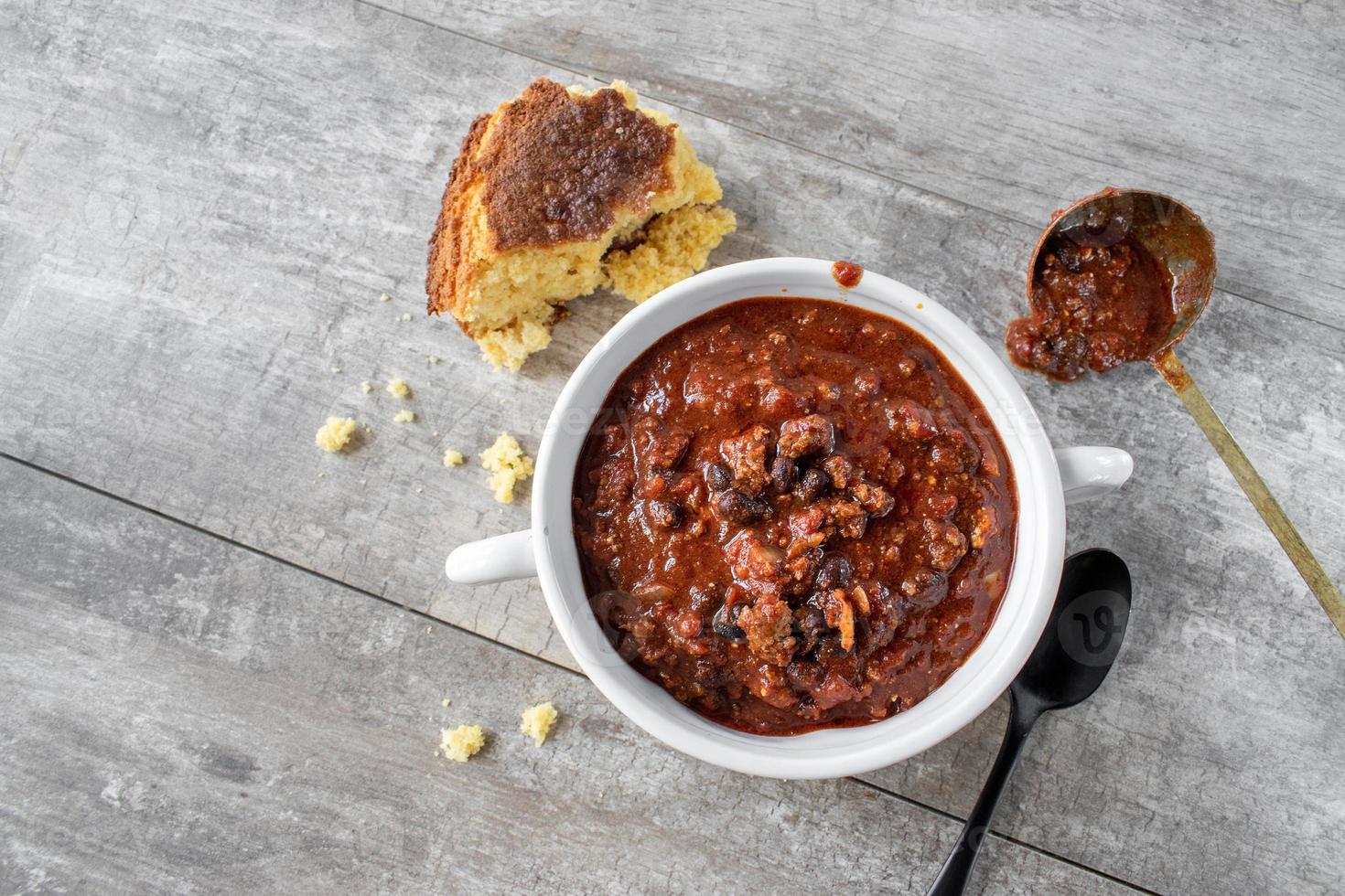 bowl of chili with black beans and cornbread flat lay photo